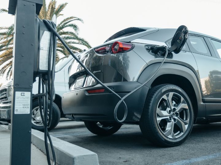 A sleek electric car plugged into a charger, showcasing the shift towards sustainable transport solutions.